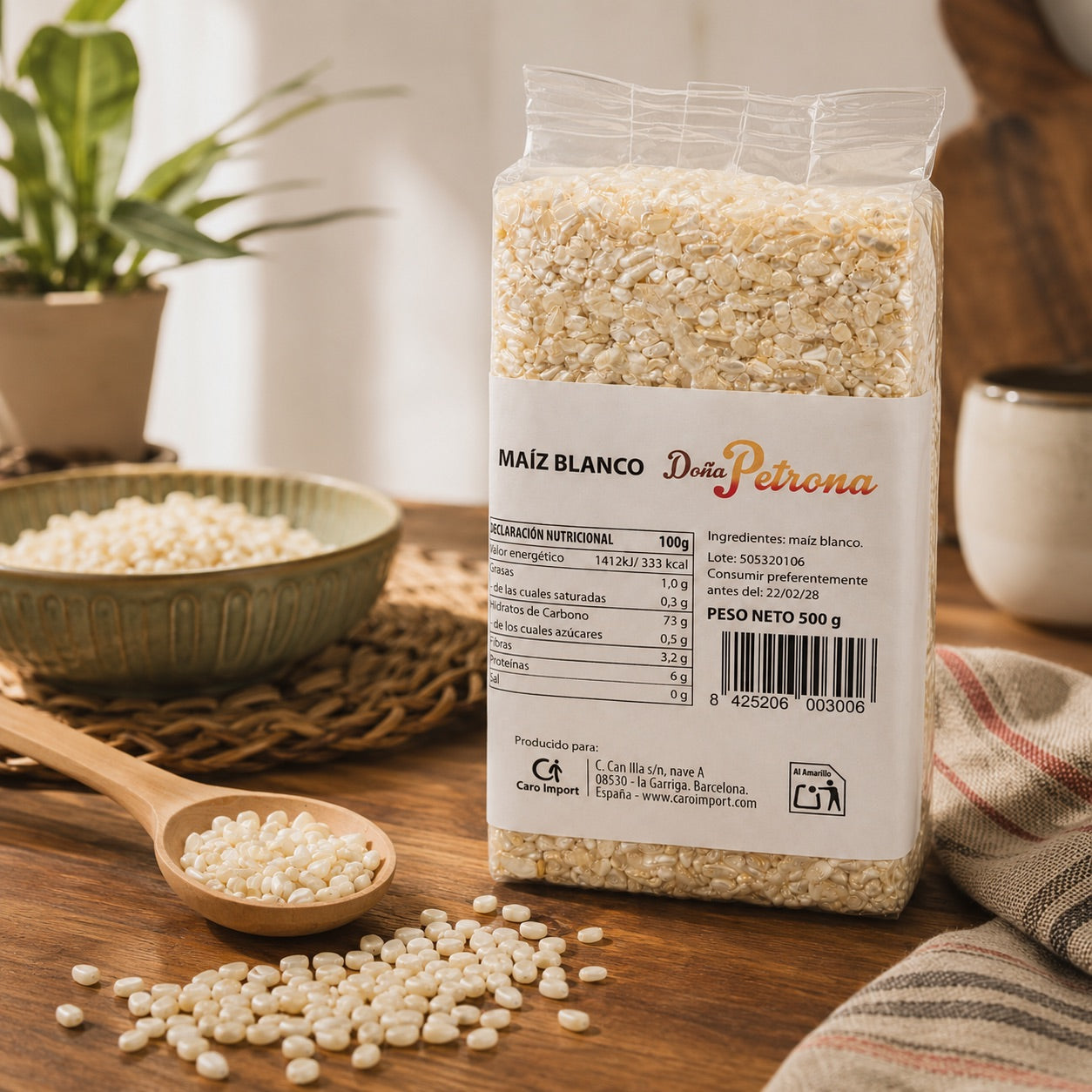 Doña Petrona white corn 500g pack on a wooden kitchen table with a wooden spoon and a bowl of white corn kernels